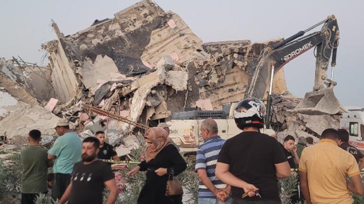 Ağır hasarlı bina yıkım sırasında iş makinesinin üzerine devrildi